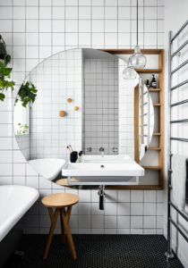 Maike Design bathroom with large round mirror and wall hung vanity
