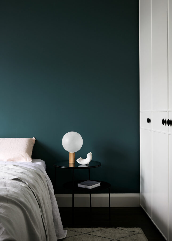 Maike Design dark teal bedroom with custom wardrobe door detail. Linen sheets and artwork.