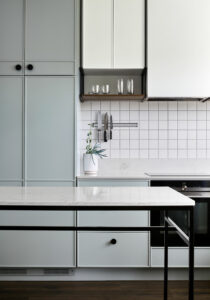 Maike Design light green kitchen. Custom cupboard design, black handles and marble benchtop.