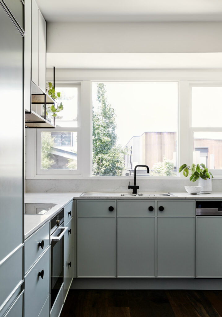 Maike Design light green kitchen. Custom cupboard design, black handles and marble benchtop.