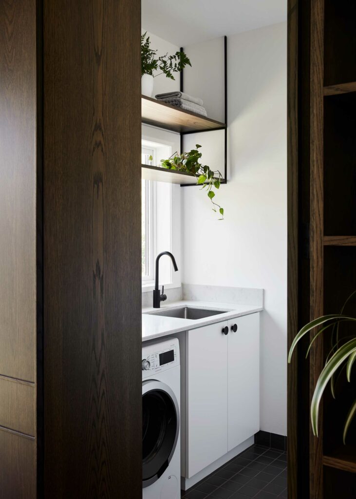 Maike Design timber door through to laundry. Open timber shelves and marble benchtop