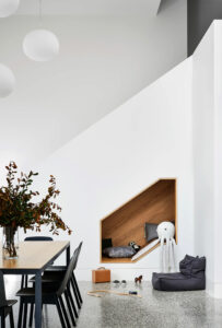 Maike Design dining room with timber play nook. Double height space with polished concrete floor