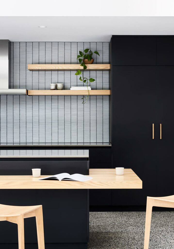 Maike Design Black kitchen. Tiled splashback and timber shelves.