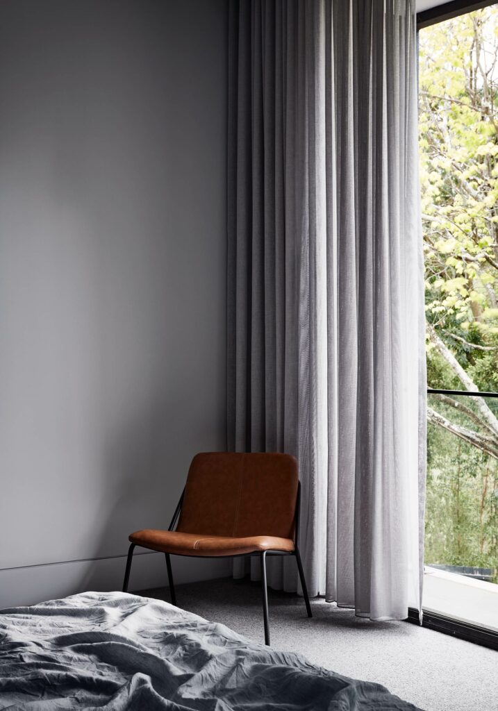 Maike Design bedroom. Sheer curtain and large window. Leather chair